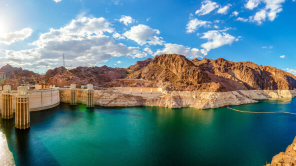 panoramic photo with landmarks from left to right: Hite Crossing Bridge, Lake Powell with notably low water level and Hoover Dam