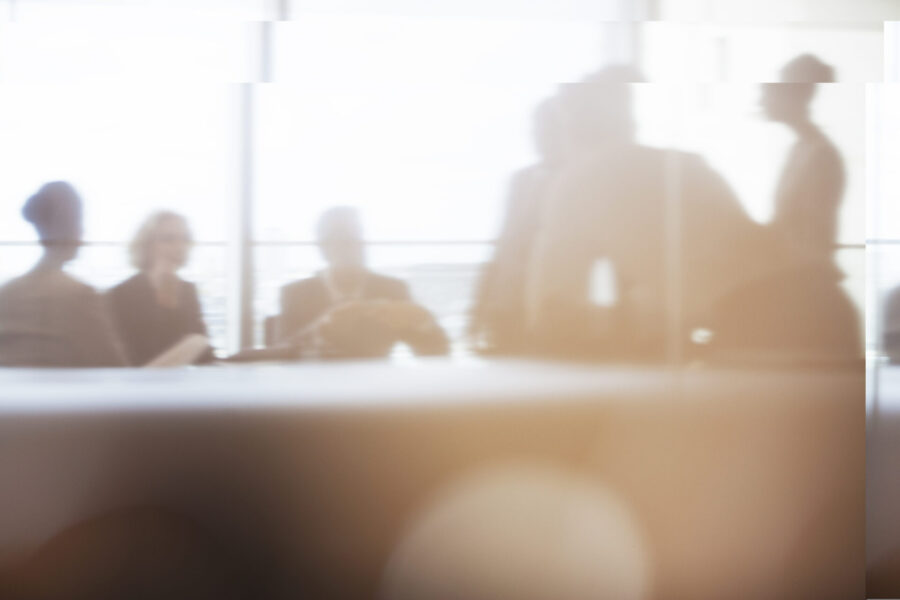 Silhouette of business people in meeting, focusing on data and reports to inform decision-making and policy