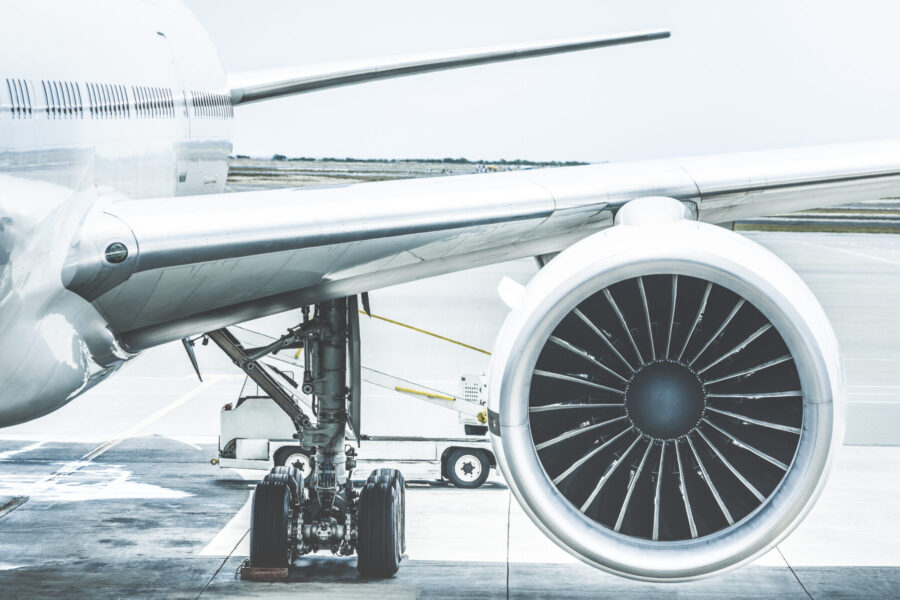 Detail of airplane engine wing at terminal gate before takeoff.
