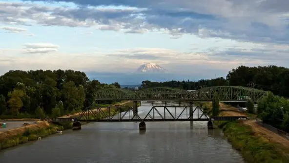 Pierce County, Washington river & bridge in foreground and Mount Rainer among clouds in background