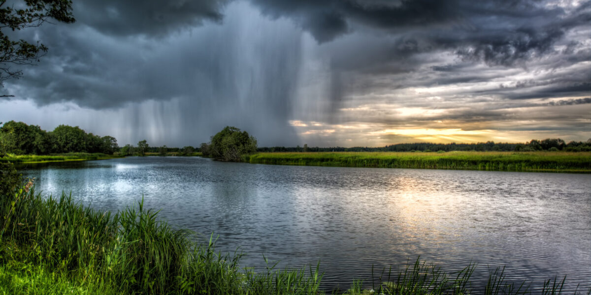 photo intense rainstorm by a river