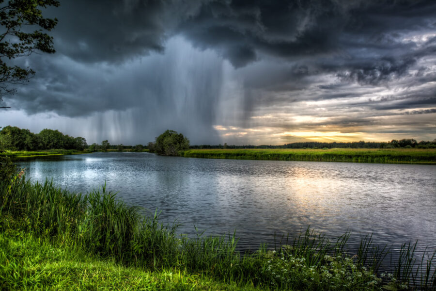 photo intense rainstorm by a river