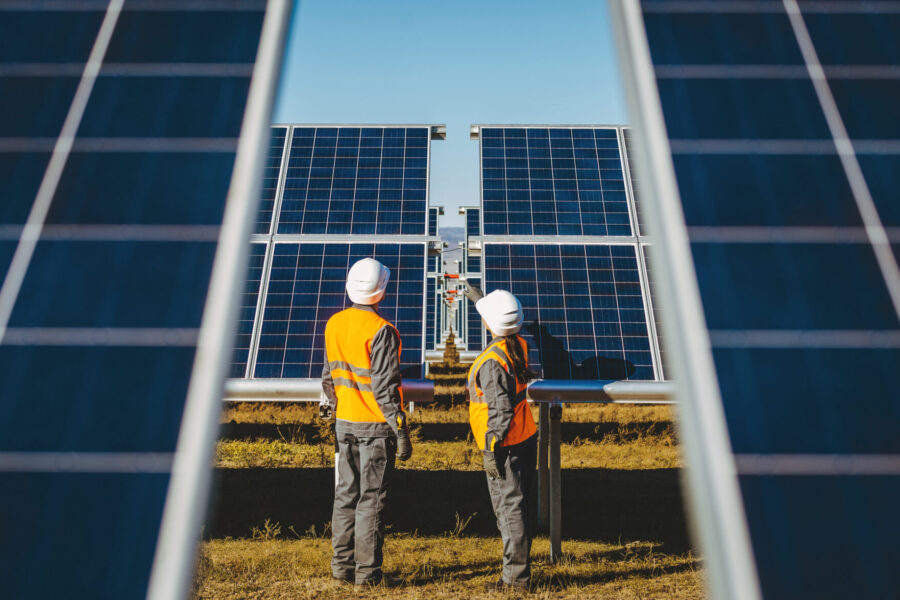 photo two operators inspect solar PV panels in a utility-scale solar farm