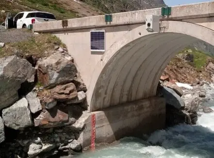 photo of bridge-mounted RQ-30 non-contact discharge radar; staff gauge used to confirm water level